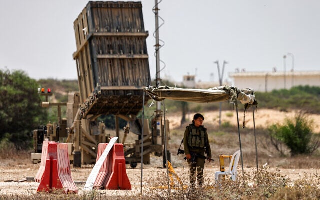 Illustrative: An Israeli soldier stands near an Iron Dome air defense system battery, deployed in southern Israel on August 6, 2022. (Menahem Kahana/AFP) Illustrative: An Israeli soldier stands near an Iron Dome air defense system battery, deployed in southern Israel on August 6, 2022. (Menahem Kahana/AFP)