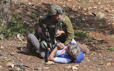 A member of the Israeli security forces scuffles with a protester as Palestinian and Israeli peace activists demonstrate at the entrance of Huwara in the West Bank, on March 3, 2023. (Jaafar ASHTIYEH / AFP) A member of the Israeli security forces scuffles with a protester as Palestinian and Israeli peace activists demonstrate at the entrance of Huwara in the West Bank, on March 3, 2023. (Jaafar ASHTIYEH / AFP)