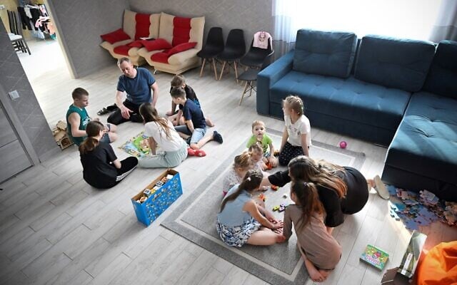 Russian pastor Roman Vinogradov (L) plays a board game with some of the 12 Ukrainian children he and his wife are fostering outside the Siberian city of Novosibirsk on March 10, 2023. (Alexander Nemenov/AFP) Russian pastor Roman Vinogradov (L) plays a board game with some of the 12 Ukrainian children he and his wife are fostering outside the Siberian city of Novosibirsk on March 10, 2023. (Alexander Nemenov/AFP)