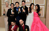 (From L) The cast and crew of 'Everything Everywhere All at Once' Jamie Lee Curtis, Ke Huy Quan, James Hong, Jonathan Wang, Michelle Yeoh, Stephanie Hsu, Daniel Kwan (bottom L), and Daniel Scheinert (bottom R), pose with their Oscar trophies in the press room during the 95th Annual Academy Awards at the Dolby Theatre in Hollywood, California on March 12, 2023. "Everything Everywhere All At Once" producers Daniel Kwan, Daniel Scheinert and Jonathan Wang (Photo by Frederic J. Brown / AFP)