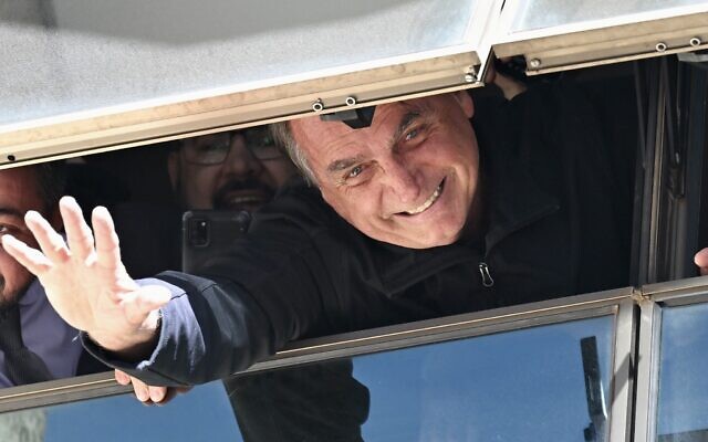 Former Brazilian president Jair Bolsonaro greets supporters from a window at the Liberal Party headquarters of n Brasilia on March 30, 2023 (EVARISTO SA / AFP)