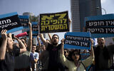 Tech workers protest Israel's right-wing government in Tel Aviv, on Januay 24, 2023. The Hebrew on the blue sign reads: 'No democracy, no high tech; and the yellow sign reads: "No to the coup d'etat.' (AP/ Maya Alleruzzo)