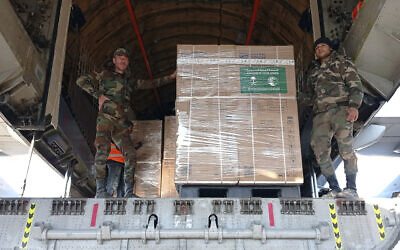 In this photo released by the official Syrian state news agency SANA, Syrian soldiers unload humanitarian aid sent from Saudi Arabia following a devastating earthquake, at the airport in Aleppo, Syria, Tuesday, Feb. 14, 2023. (SANA via AP)
