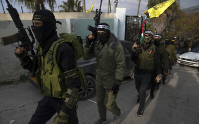 Palestinian gunmen take part in a military parade during a memorial ceremony for two members of the Islamic Jihad terror group, in the West Bank village of Jaba, near Jenin, February 24, 2023. (AP Photo/Nasser Nasser)