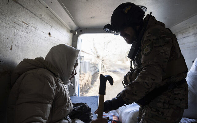A Ukrainian police officer helps an elderly woman as she evacuates to safe areas in Chasiv Yar near Bakhmut, Ukraine, March 4, 2023. (AP Photo/Evgeniy Maloletka) A Ukrainian police officer helps an elderly woman as she evacuates to safe areas in Chasiv Yar near Bakhmut, Ukraine, March 4, 2023. (AP Photo/Evgeniy Maloletka)