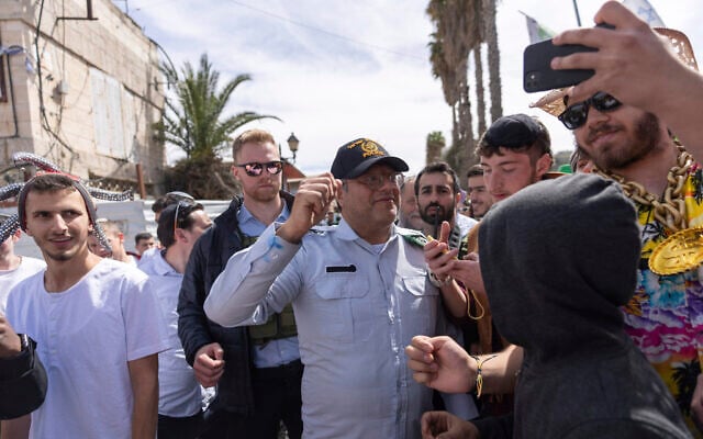 National Security Minister Itamar Ben Gvir, center, dressed in a costume combining elements of various uniforms of forces under his command, celebrates the Jewish holiday of Purim, in the West Bank city of Hebron, March 7, 2023. (AP/Ohad Zwigenberg) National Security Minister Itamar Ben Gvir, center, dressed in a costume combining elements of various uniforms of forces under his command, celebrates the Jewish holiday of Purim, in the West Bank city of Hebron, March 7, 2023. (AP/Ohad Zwigenberg)