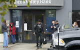 A Brinks worker walks toward a truck after exiting Silicon Valley Bank in Santa Clara, Calif., Friday, March 10, 2023. The U.S rushed to seize the assets of Silicon Valley Bank on Friday after a run on the bank, the largest failure of a financial institution since Washington Mutual during the height of the financial crisis more than a decade ago. (AP Photo/Jeff Chiu)