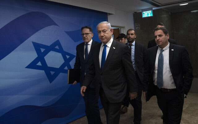 Prime Minister Benjamin Netanyahu, center, arrives to chair the weekly cabinet meeting in Jerusalem, Sunday, March 12, 2023. (AP Photo/Maya Alleruzzo, Pool) Prime Minister Benjamin Netanyahu, center, arrives to chair the weekly cabinet meeting in Jerusalem, Sunday, March 12, 2023. (AP Photo/Maya Alleruzzo, Pool)