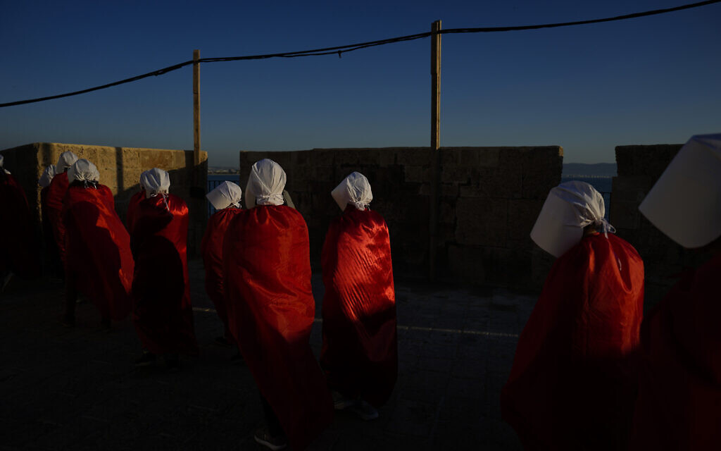 Protesters supporting women's rights dressed as characters from "The Handmaid's Tale" TV series attend a protest against the government's plans to overhaul the judicial system in the old port of Acre in northern Israel, March 16, 2023. (AP/Ariel Schalit)