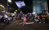 Demonstrators block a highway during protest against plans by Prime Minister Benjamin Netanyahu's government to overhaul the Israel's judicial system, in Tel Aviv, March 18, 2023. (AP Photo/ Ohad Zwigenberg)