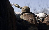 A Ukrainian soldier of the 28th brigade fires a grenade launcher on the frontline during a battle with Russian troops near Bakhmut, Donetsk region, Ukraine, March 24, 2023. (AP Photo/Libkos)