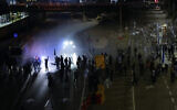 Israeli police use a water cannon to disperse Israelis blocking a highway during a protest against plans by Prime Minister Benjamin Netanyahu's government to overhaul the judicial system in Tel Aviv, Israel, March 25, 2023. (AP Photo/Ariel Schalit)