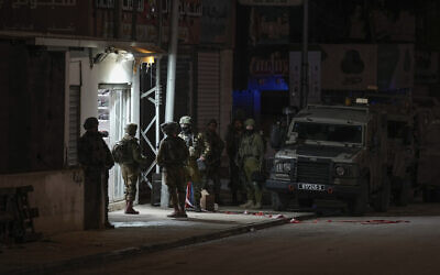 Israeli soldiers are deployed at the scene where a Palestinian gunman opened fire at soldiers in the West Bank town of Huwara, March 25, 2023. (AP/Majdi Mohammed)