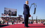 Former US President Donald Trump stands while a song, 'Justice for All,' is played during a campaign rally at Waco Regional Airport, as footage from the January 6, 2021, insurrection at the US Capitol is displayed in the background, March 25, 2023, in Waco, Texas. (AP Photo/Evan Vucci)