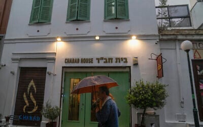 A man holding an umbrella walks past a Jewish restaurant that Greek officials believe was one of the targets of a planned terrorist attack, in central Athens, Tuesday, March 28, 2023. (AP Photo/Thanassis Stavrakis)