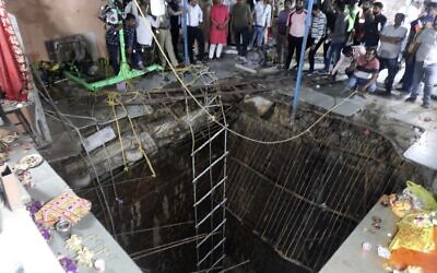 People stand around a structure built over an old temple well that collapsed, as a large crowd of devotees gathered for the Ram Navami Hindu festival in Indore, India, March 30, 2023. (AP Photo)