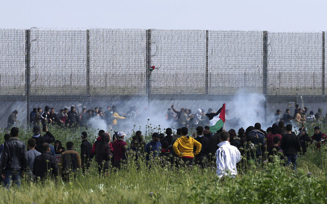 Palestinians try to destroy the fence while Israeli troops shot teargas during clashes along Gaza's border fence with Israel, east of Gaza City, March 30, 2023. (AP Photo/Adel Hana) Palestinians try to destroy the fence while Israeli troops shot teargas during clashes along Gaza's border fence with Israel, east of Gaza City, March 30, 2023. (AP Photo/Adel Hana)