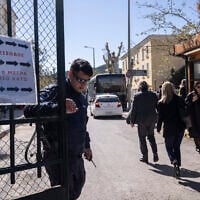 Illustrative - A Greek police officer closes the entrance of the court house following the transfer of suspects that have been charged with membership in a terrorist organization, in Athens, March 2023. (AP Photo/Petros Giannakouris)