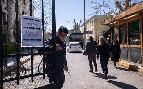 Illustrative - A Greek police officer closes the entrance of the court house following the transfer of suspects that have been charged with membership in a terrorist organization, in Athens, March 2023. (AP/Petros Giannakouris)