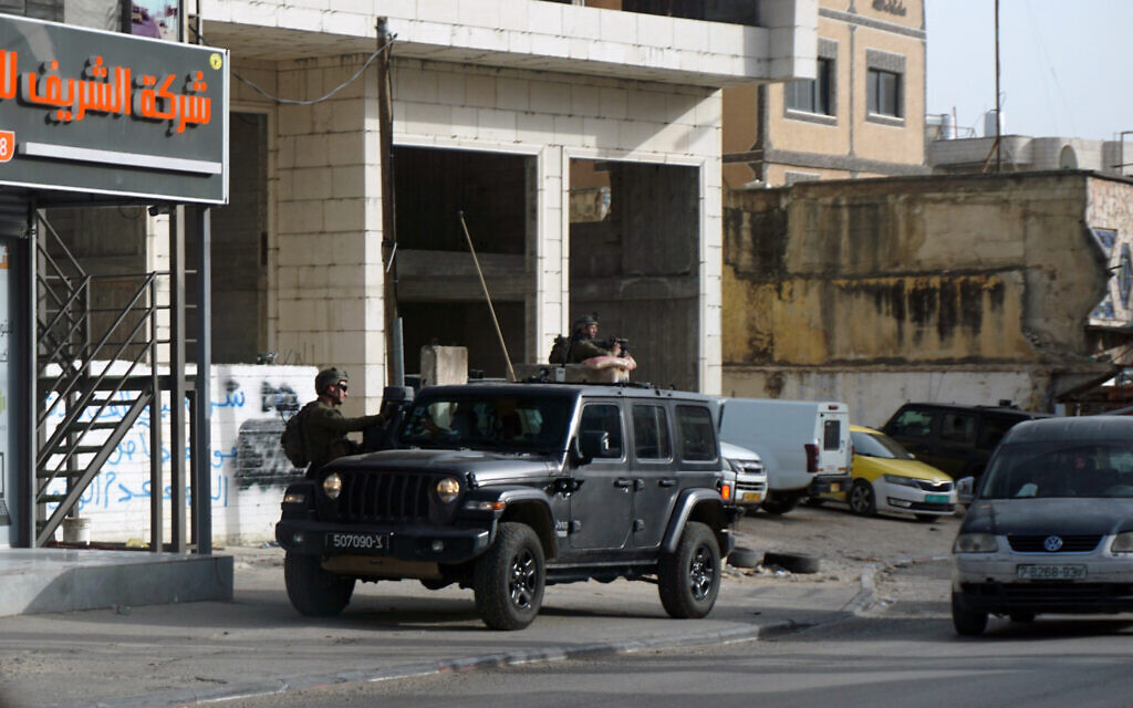 Israeli soldiers stand guard in the West Bank town of Huwara, March 5, 2023. (Emanuel Fabian/Times of Israel) Israeli soldiers stand guard in the West Bank town of Huwara, March 5, 2023. (Emanuel Fabian/Times of Israel)