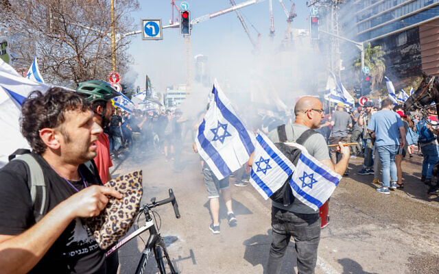Demonstrators block a road and clash with police who deploy tear gas as they protest against the government's planned judicial overhaul, in Tel Aviv, March 1, 2023. (Erik Marmor/Flash90)