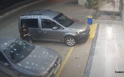 Screen capture from video of a masked man using an axe to attack a Palestinian man in a car in the West Bank town of Huwara, March 6, 2023. (YouTube; used in accordance with Clause 27a of the Copyright Law) Screen capture from video of a masked man using an axe to attack a Palestinian man in a car in the West Bank town of Huwara, March 6, 2023. (YouTube; used in accordance with Clause 27a of the Copyright Law)