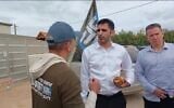 Screen capture from video of Communications Minister Shlomo Karhi, center, speaking with protesters outside his home in Moshav Zimrat, March 7, 2023. (Channel 12, Used in accordance with Clause 27a of the Copyright Law)