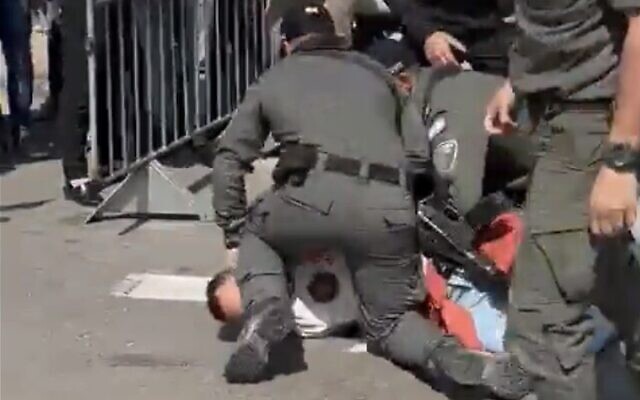 Screen capture from video of a police officer kneeling on the neck of a protester during clashes at a demonstration against the government's planned overhaul of the judiciary, Tel Aviv, February 1, 2023. (Twitter. Used in accordance with Clause 27a of the Copyright Law)