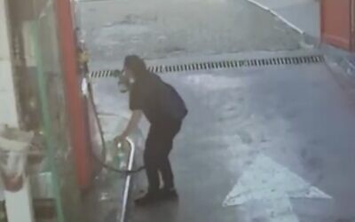 Screen capture from video showing a woman filling a bottle with gaslone that she then apparently used in an attempted arson attack on a Tiberias municipal building, March 26, 2022. (Twitter.  Used in accordance with Clause 27a of the Copyright Law)