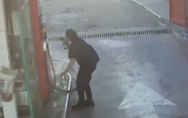 Screen capture from video showing a woman filling a bottle with gaslone that she then apparently used in an attempted arson attack on a Tiberias municipal building, March 26, 2022. (Twitter. Used in accordance with Clause 27a of the Copyright Law) Screen capture from video showing a woman filling a bottle with gaslone that she then apparently used in an attempted arson attack on a Tiberias municipal building, March 26, 2022. (Twitter. Used in accordance with Clause 27a of the Copyright Law)