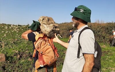 Students from the Kinneret Academic college help bring the 62-pound lioness carving from Ein Nashut to their bus on March 1, 2023, in the Golan Heights. (courtesy Mordechai Aviam)