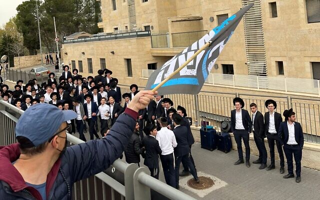 Members of the 'Brothers in Arms' reservist protest group demonstrate outside the Jerusalem home of Shas leader Aryeh Deri as local residents gather, March 23, 2023 (Courtesy)