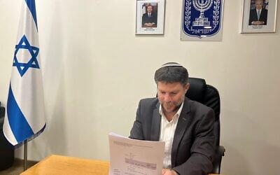 Finance Minister Bezalel Smotrich signs a directive canceling a special tax on sugary drinks, March 28, 2023. (Finance Ministry)