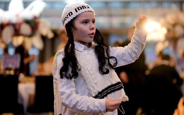 A boy dances to celebrate Purim at a party in a hotel in Berlin, Germany, March 7, 2023. (AP/Markus Schreiber) A boy dances to celebrate Purim at a party in a hotel in Berlin, Germany, March 7, 2023. (AP/Markus Schreiber)