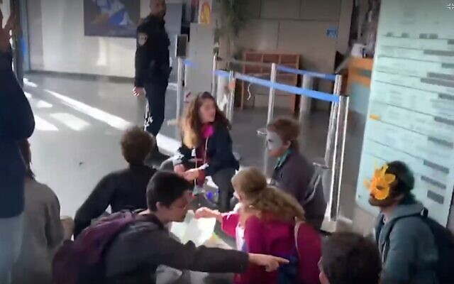 Activists glue themselves to the entrance of a building housing government offices in Tel Aviv, Marc 8, 2023. (Screen grab; used in accordance with Clause 27a of the Copyright Law) Activists glue themselves to the entrance of a building housing government offices in Tel Aviv, Marc 8, 2023. (Screen grab; used in accordance with Clause 27a of the Copyright Law)