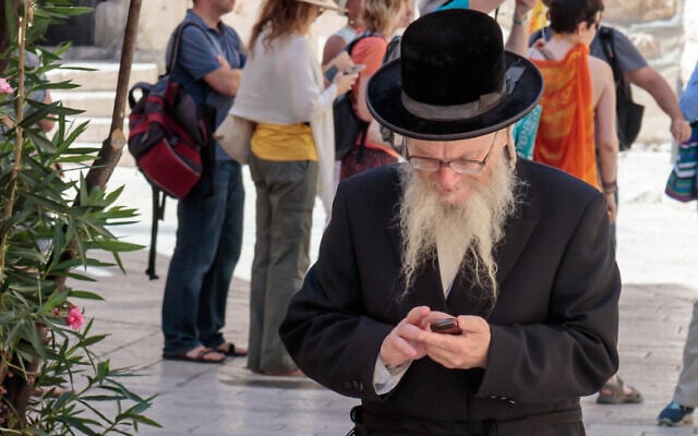 Illustrative: A Haredi man looks at his mobile phone in Jerusalem, Israel (svarshik/iStock by Getty Images) Illustrative: A Haredi man looks at his mobile phone in Jerusalem, Israel (svarshik/iStock by Getty Images)