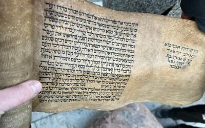 An Israeli rescue worker holds a scroll found in Antakya, Turkey on Feb. 16, 2023. (IDF Spokesperson)
