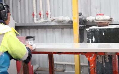 A man works a caesarstone slab (YouTube video screeshot; Used in accordance with Clause 27a of the Copyright Law)