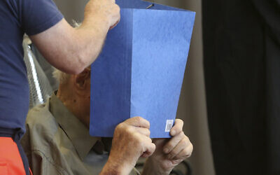 Former Nazi concentration camp guard Josef Schuetz hides his face with a folder as he arrives on June 28, 2022 at a gym used as a makeshift courtroom in Brandenburg an der Havel, eastern Germany, where the verdict was delivered.(Adam BERRY / AFP)