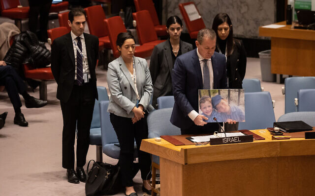 Israel's Ambassador to the United Nations Gilad Erdan (2R) and other Israeli delegates hold a moment of silence for terror victims brothers Yaakov and Asher Palley during the United Nations Security Council meeting on the situation in the Middle East, at the United Nations headquarters in New York City on February 20, 2023. (Yuki IWAMURA/AFP) Israel's Ambassador to the United Nations Gilad Erdan (2R) and other Israeli delegates hold a moment of silence for terror victims brothers Yaakov and Asher Palley during the United Nations Security Council meeting on the situation in the Middle East, at the United Nations headquarters in New York City on February 20, 2023. (Yuki IWAMURA/AFP)