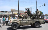 Sudanese greet army soldiers loyal to army chief Abdel Fattah al-Burhan, in the Red Sea city of Port Sudan on April 16, 2023.(AFP)