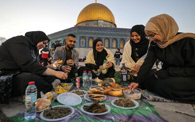 People sit together to break their Ramadan fast at the end of the last day of the Muslim holy month and the start of the holiday of Eid al-fitr, near the Dome of the Rock shrine at the Aqsa Mosque compound on the Temple Mount in the Old City of Jerusalem on April 20, 2023. (Ahmad Gharabli/AFP)