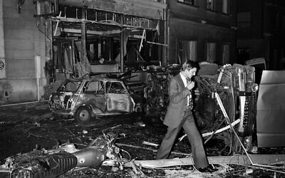 In this file photo taken on October 3, 1980, an inspector walks amid car wreckage after a bomb exploded at the synagogue rue Copernic in Paris. (Georges Gobet/AFP)