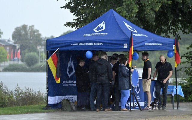 File: People take refuge from rain under a tent of the youth wing of the far-right Alternative for Germany (AfD) party as the AfD meets for the launch of the electoral campaign ahead of the 2021 federal elections, in Schwerin, northern Germany, on August 10, 2021. (John MACDOUGALL/AFP) File: People take refuge from rain under a tent of the youth wing of the far-right Alternative for Germany (AfD) party as the AfD meets for the launch of the electoral campaign ahead of the 2021 federal elections, in Schwerin, northern Germany, on August 10, 2021. (John MACDOUGALL/AFP)