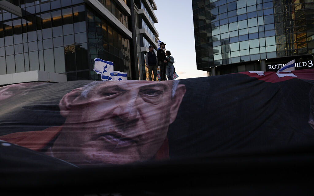 A large banner depicting Prime Minister Benjamin Netanyahu is readied for a protest against plans by the leader's hard-right government to overhaul the judicial system, in Tel Aviv, Saturday, April 1, 2023. (AP Photo/Ohad Zwigenberg)