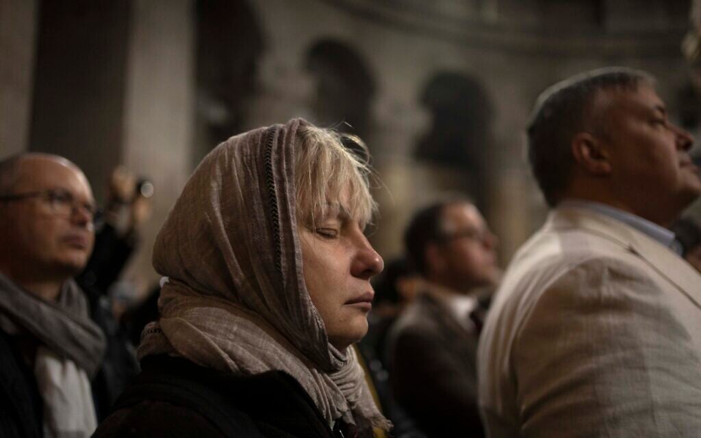A woman takes part in Palm Sunday Mass in the Church of the Holy Sepulchre, where many Christians believe Jesus was crucified, buried and rose from the dead, in the Old City of Jerusalem, April 2, 2023. (AP Photo/Maya Alleruzzo)