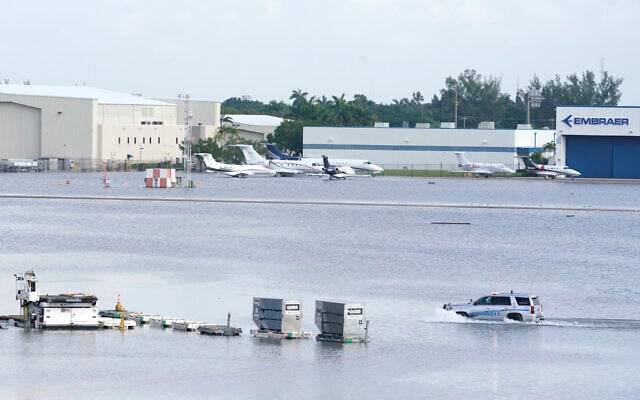 A truck drives on the flooded runway at Fort Lauderdale- Hollywood International Airpor, April 13, 2023, in Fort Lauderdale, Florida. (AP Photo/Marta Lavandier) A truck drives on the flooded runway at Fort Lauderdale- Hollywood International Airpor, April 13, 2023, in Fort Lauderdale, Florida. (AP Photo/Marta Lavandier)