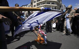 Iranian demonstrators burn representations of the Israeli and the US flags in their rally to mark Jerusalem Day, an annual show of support for the Palestinians, in Tehran, Iran, Friday, April 14, 2023. (AP/Vahid Salemi)