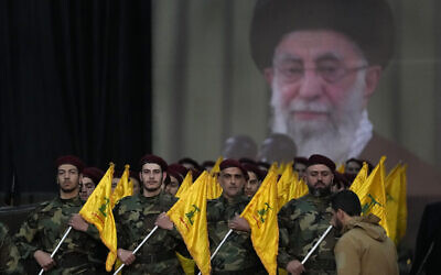 Hezbollah fighters parade in front of a poster showing Supreme Leader Ayatollah Khamenei during a rally to mark Jerusalem day, in a southern suburb of Beirut, Lebanon, Friday, April 14, 2023. (AP Photo/Hussein Malla)