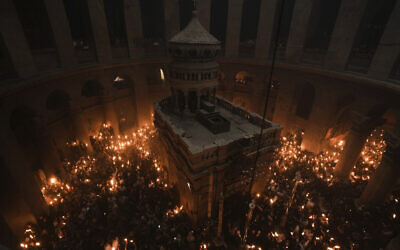 Christian pilgrims hold candles during the Holy Fire ceremony, a day before Easter, at the Church of the Holy Sepulcher, in Jerusalem's Old City, April 15, 2023. (AP Photo/Mahmoud Illean)